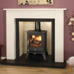 Modern black wood burning stove in a fireplace with white mantel.