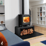 Modern wood burning stove with fire visible, in a contemporary living room setting.